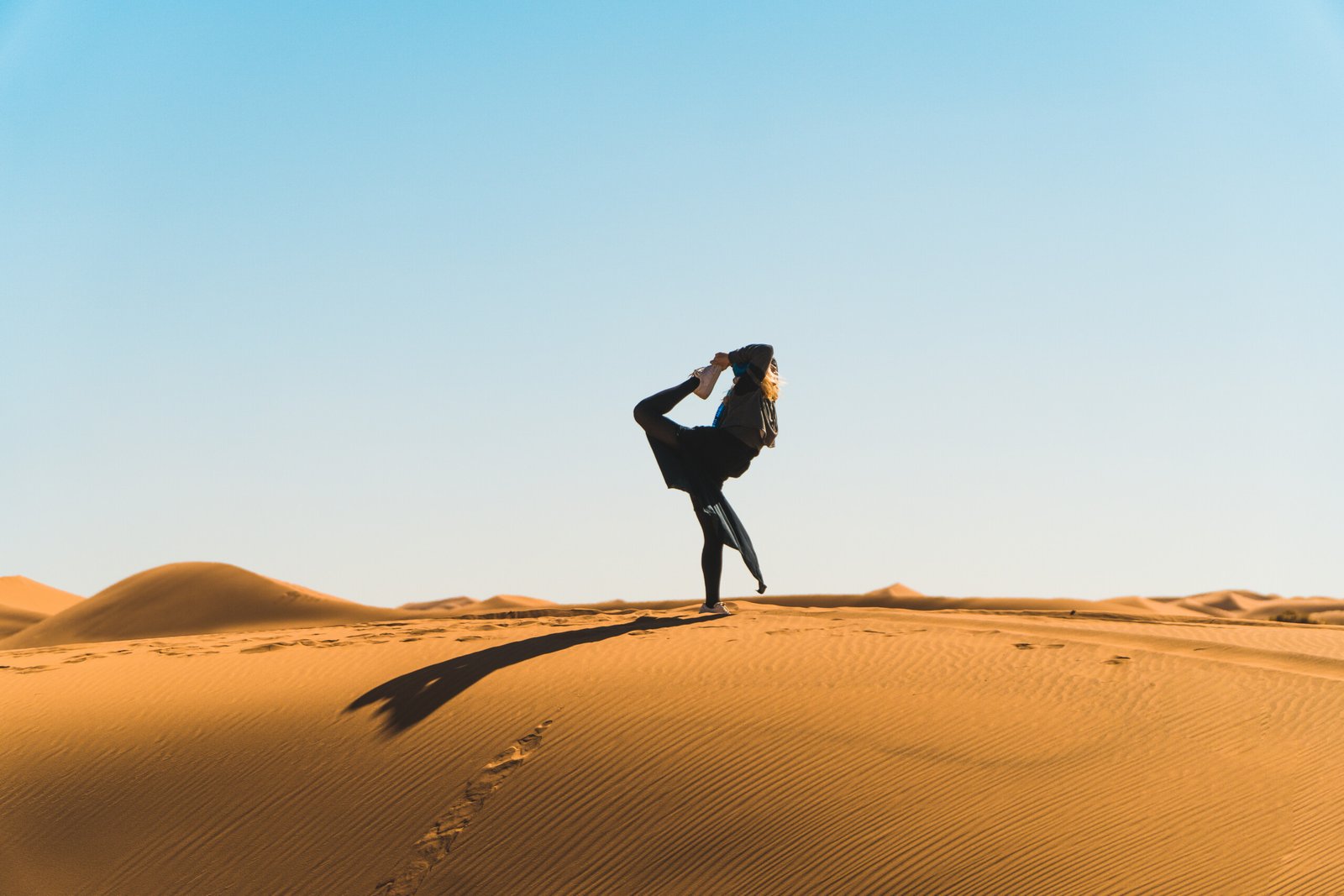 Yoga in Sahara Desert dunes Morocco sunrise